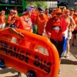 An orange bus dinghy leads march in Bristol for women’s cricket